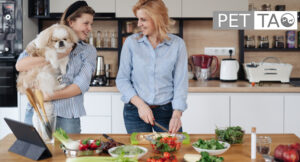 mother and daughter cooking energetically cooling food for dog